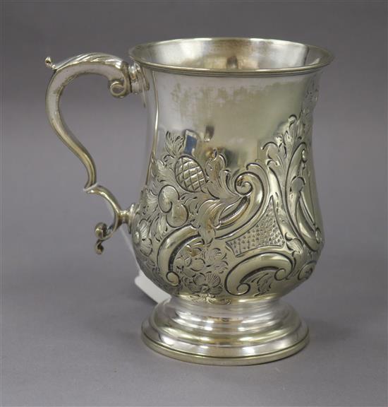 A white metal embossed engraved baluster mug, unmarked,